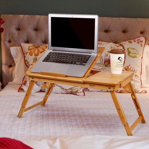 A comfortable desk to use their laptop while in bed